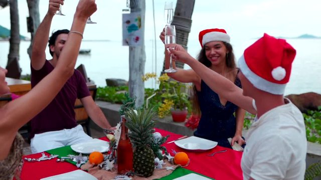 Group of happy people of mixed race friends celebrate Christmas and New Year 2020 at a tropical resort