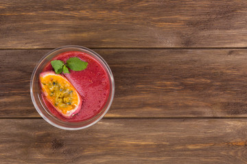 Berry dessert with passion fruit on wooden background. Recipe, healthy food concept. Top view, flat lay, copy space