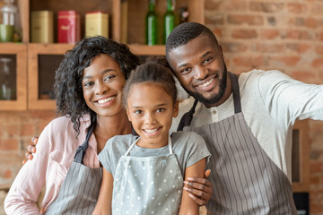 Portrait of happy family taking selfie over kitchen background
