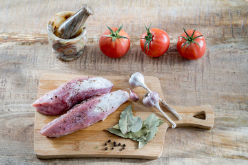 Food products on the wooden background. Raw meat, vegetables and spices are the ingredients for dinner.