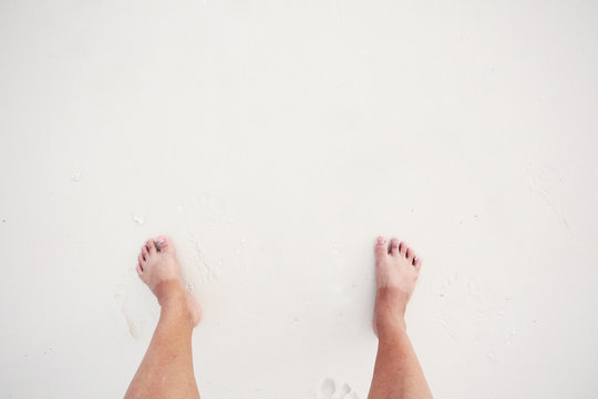 Asian woman have Two-color foot skin with sun-bath on white beach and sea