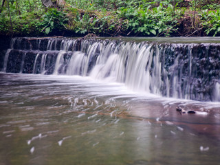Fototapeta premium landscape with small waterfall (cascade) on river with motion blur. 