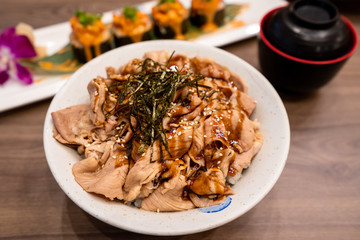 Grilled pork slice with rice served in bowl, one of most famous Japanese food menu. Selective and close up photo at pork piece.