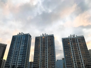 Fototapeta na wymiar Tall beautiful monolithic-frame panel buildings, new buildings, skyscrapers, houses made of glass and concrete with many windows in the new district of the city. The background