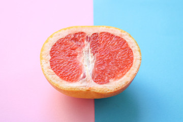 Half a grapefruit isolated on pink and blue background