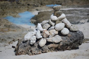 Fototapeta na wymiar Pyramid of unevenly stacked round gray stones on the sea coast