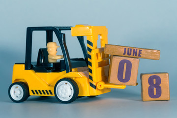 june 8th. Day 8 of month, Construction or warehouse calendar. Yellow toy forklift load wood cubes with date. Work planning and time management. summer month, day of the year concept