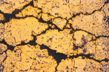 stone surface with cracks, covered with yellow paint