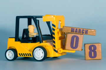 march 8th. Day 8 of month, Construction or warehouse calendar. Yellow toy forklift load wood cubes...