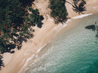 Aerial view of lying woman on the beach . Young woman on the sea. Phuket. Thailand. Top view. Seascape with girl on the seashore, blue water and waves. Travel