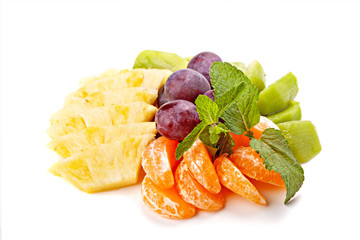 Sliced fresh fruits. Pineapple, tangerine, kiwi and large grapes.