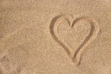 Fototapeta na wymiar Heart sign on the sand on the beach