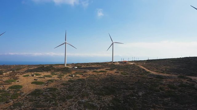Aerial view of Wind turbines Energy Production. Electricity is generated by electric generators hidden inside turbine. Aerial view of windmills turning at sunset, wind power turbines generating clean