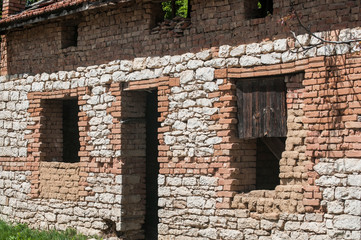 Old rural abandoned stone house facade closeup in sunny day