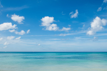 Caribbean landscape: azure sea, deep blue sky and white small clouds