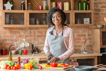 Young beautiful woman cooking healthy salad at kitchen