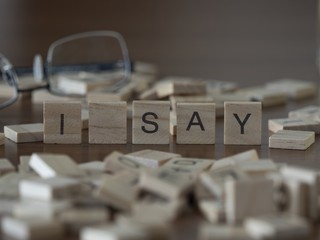 The concept of I say represented by wooden letter tiles