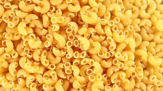 Elbow macaroni noodles 4k video spinning clockwise slowly top down view