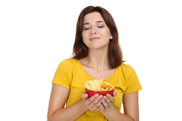 Young woman with potato chips in bowl on white background