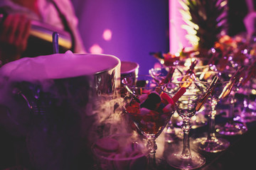 View of alcohol setting on catering banquet table, row line of different colored alcohol cocktails on a party, martini, vodka, and others on decorated catering bouquet table event