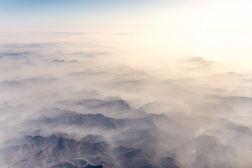 Aerial landscape mountain lost in thick fog in China in the morning sunlight, bird eye view...