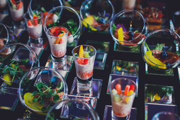 Fototapeta na wymiar Beautifully decorated catering banquet table with different food snacks and appetizers on corporate christmas birthday party event or wedding celebration, different vegan vegetarian snacks