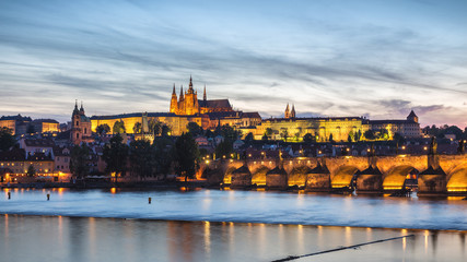 Prague Castle and the Charles Bridge at sunset in Prague, Czech Republic, Vltava river in foreground