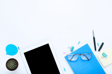 Tablet computer with office supplies on white background