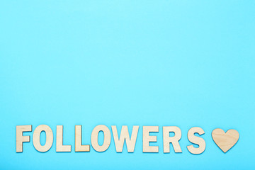 Word Followers by wooden letters on blue background