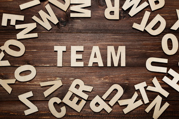 Word Team by wooden letters on brown table