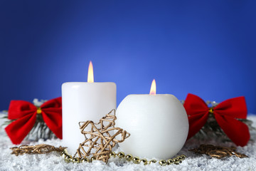 Christmas candles with decorative star and red bows on blue background