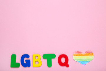 Abbreviation LGBT with paper heart on pink background