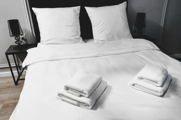 White towel on bed decoration in bedroom interior.