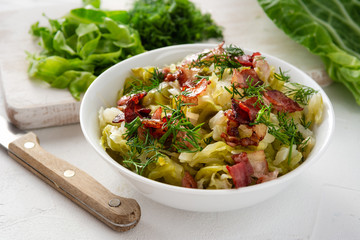 Stewed young cabbage with dill and grilled bacon.