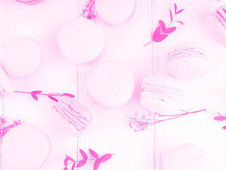 Gift box and macarons on whie table background with copy space to write. several white and pink sweet tender macaroons on a white background. neon tinted background