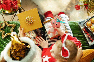 Fototapeta premium stylish mother and daughter opening Christmas present