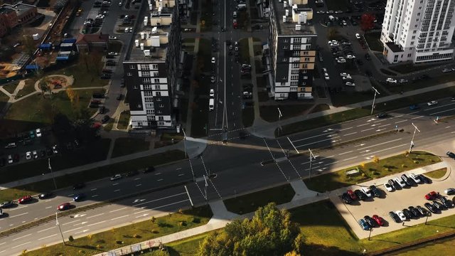 Top view, drone tilts up on National Library in Minsk flying above beautiful city streets and apartment block buildings.