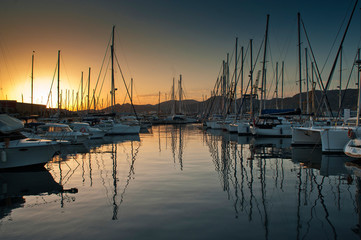 Fototapeta na wymiar wooden surface pier and boats docked at dawn in the marina of Cartajena