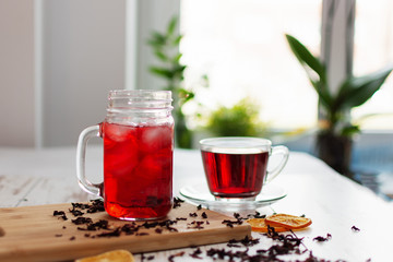 Cup of hibiscus tea (karkade, red sorrel, Agua de flor de Jamaica) on a table.