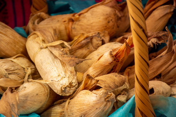 Canasta con tamales envueltos en hoja de mazorca de maíz, son un alimento mexicano y...