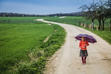 petite fille avec un parapluie sur un chemin