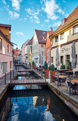 Old street with a water canal and restaurant in Memmingen, Germany.