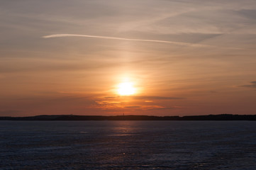 Low winter sun over iced lake
