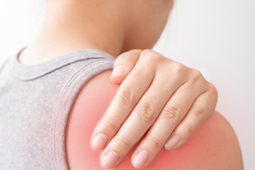 Woman holding hand to spot of shoulder pain