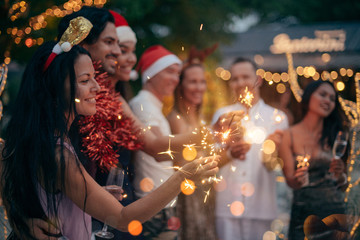 A large company has fun with champagne and sparklers in the tropics.