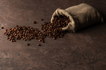 Roasted coffee beans in a bag on old rusty background with copy space