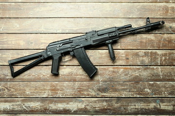 black machine gun on the background of shabby wooden floor boards