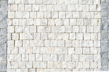 European stone pavement made of white blocks. Beautifully and evenly laid out square pavers in the city of Europe. Smooth white granite.