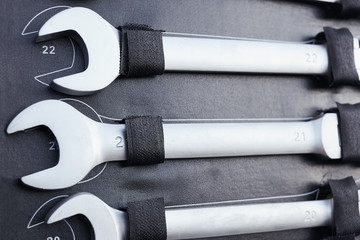 Set of tools for car repair in the box. Closeup of chrome wrench tools organized in box.