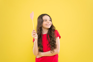 small kid yellow background. cheerful child with beautiful long hair. little beauty. birthday party time. smiling little girl party heart. party elements. happy childhood. celebrating love day
